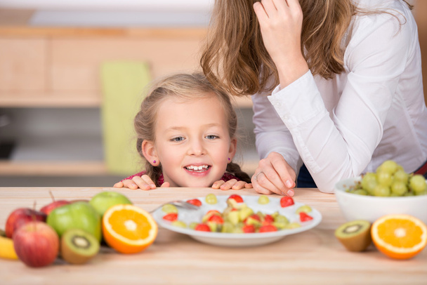 Girl Looking At Fruit Salad In Kitchen - Valokuva, kuva