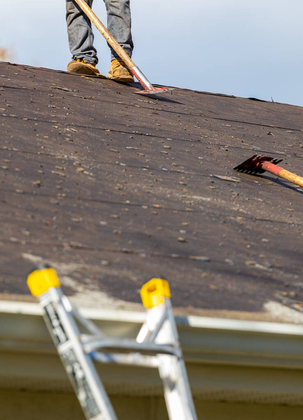 roofer removing roof shingles with roof shingle remover - Photo, Image