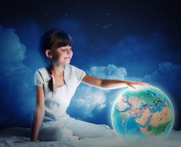 Girl sitting in bed and looking at Earth planet - Foto, immagini