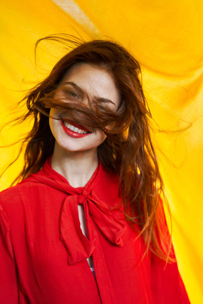 smiling woman in red dress posing yellow background - Photo, image