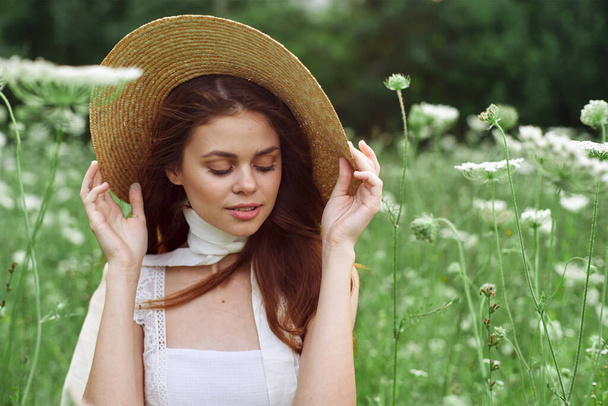 pretty woman in white dress and hat posing flowers nature - Zdjęcie, obraz
