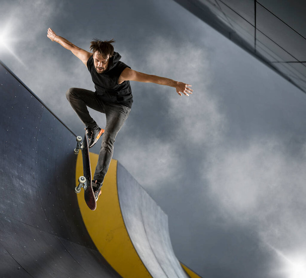 Skater doing kickflip on the ramp. Freestyle extreme sports concept - Photo, Image
