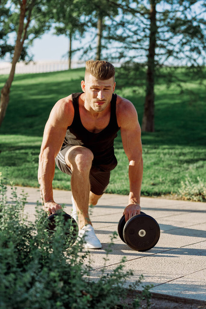athletic man with dumbbells workout outdoors motivation - 写真・画像