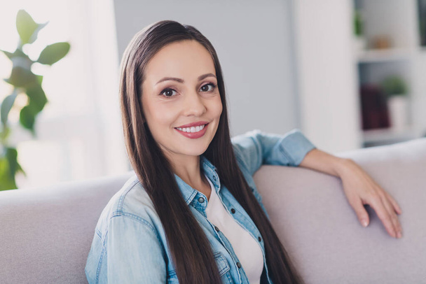Portrait of attractive confident cheerful long-haired woman resting sitting on divan safety measures staying home indoors - Foto, Bild
