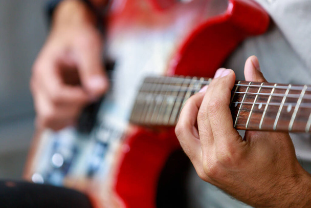 Гітара зосереджена в руках музиканта-гітариста. Фон з пробілом для копіювання тексту або написання. Вибірковий фокус
 - Фото, зображення