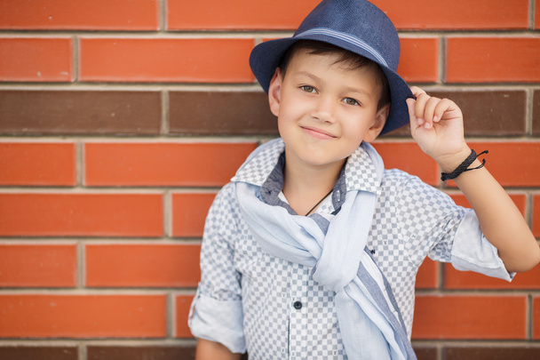 Stylish boy in Hat posing on a brick wall - Zdjęcie, obraz
