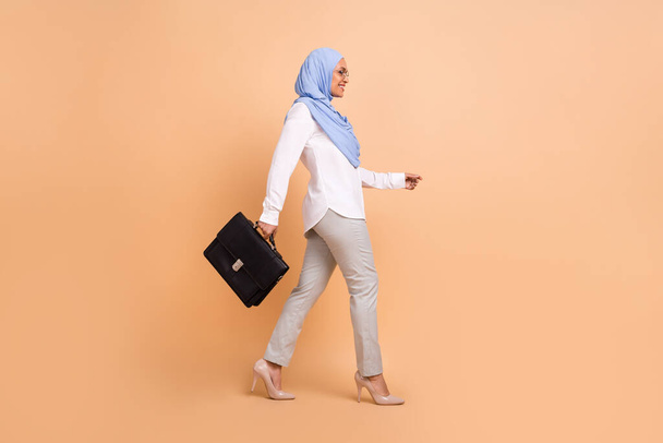 Full length profile photo of millennial east modern hr lady go with bag wear headscarf shirt eyewear pants stilettos isolated on peach background - Φωτογραφία, εικόνα