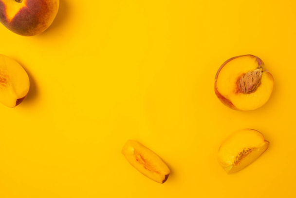 Melocotones jugosos maduros sobre fondo amarillo brillante. Vista superior de alimentos de frutas orgánicas frescas con espacio para copiar - Foto, imagen