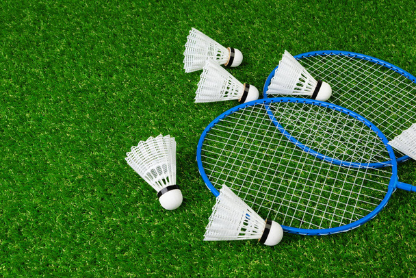 Badminton game rackets and shuttlecock on grass - Foto, afbeelding