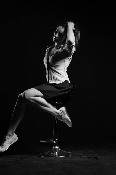 krásná mladá žena pózující v ateliéru na černém pozadí, módní styl, černá a bílá fotografie - Fotografie, Obrázek