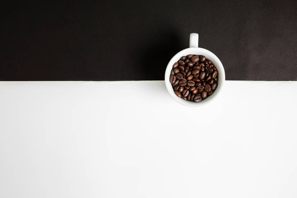 Біла чашка кави повна кавових зерен. Чисте чорно - біле тло. - Фото, зображення