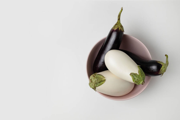 Plate with raw ripe colour eggplants with copy space on grey background. Top view. Harvest concept - Fotoğraf, Görsel