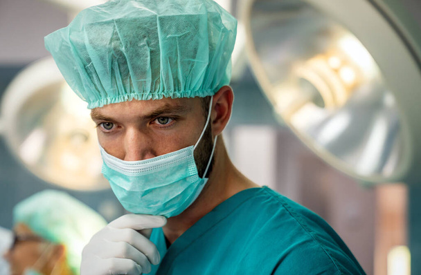 Portrait of a tired man surgeon at working hospital. Healthcare pandemic people concept - Foto, Bild