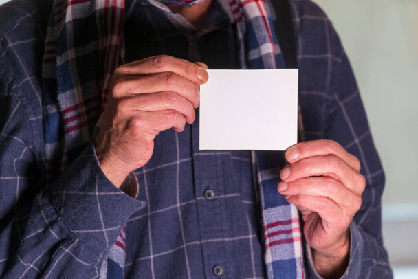 Man holding a white sheet of paper. Template for writing text on white paper - Фото, зображення