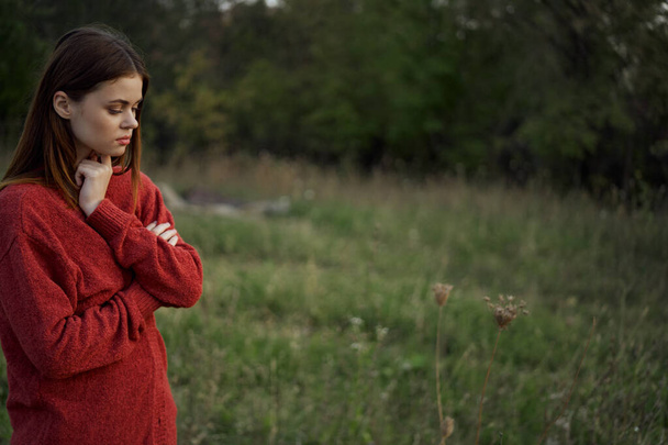 woman in a red sweater outdoors in a field walk - Foto, Imagem