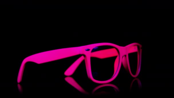 Różowe neonowe okulary odwracają się - Materiał filmowy, wideo