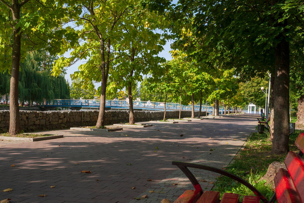 Красная деревянная скамейка в осеннем парке - Фото, изображение