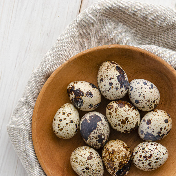 quail eggs in wooden plate over dark old wooden background. Concept of healthy eating - Valokuva, kuva