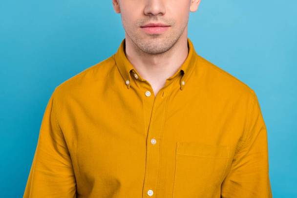 Cropped photo of serious healthy guy smooth facial skin wear yellow shirt isolated blue color background - Foto, afbeelding