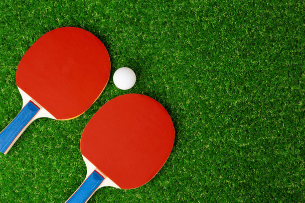Ping pong rackets and ball on grass - Foto, afbeelding