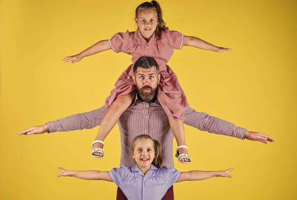 lets fly together. Two daughters with their beloved dad. having fun together. happiness. happy fathers day. family holiday. man dad with daughters. love and trust. Father and his daughters - Foto, Bild