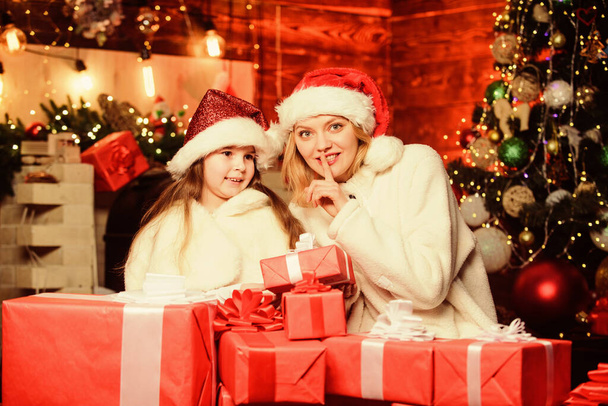 Find presents online. small child girl with mom in santa hat. xmas gift boxes. Open present. merry christmas. mother and daughter love holidays. Winter shopping sales. Happy family celebrate new year - Foto, Bild