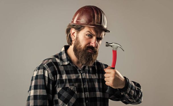 handsome bearded guy with beard and moustache hold hammer, building - Fotografie, Obrázek