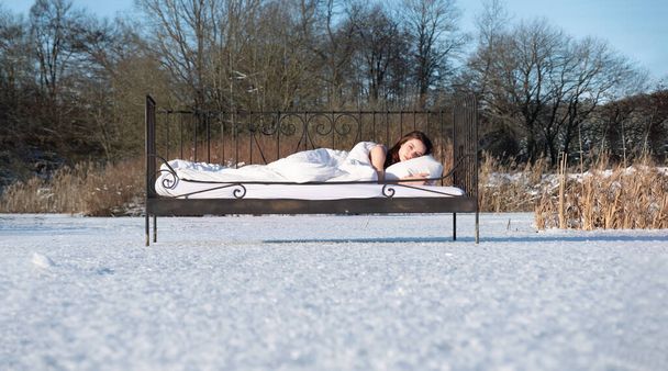 attractive, young, sexy, seductive, brunette woman in Bed, outside in the cold winter nature, on a frozen lake, copy space - 写真・画像