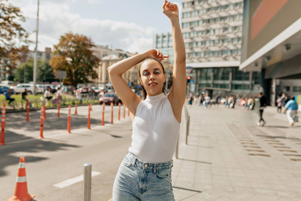 Outdoor portrait of stylish woman with bright make up in casual clothes is posing over urban city. Street style look. Autumn mood. - Foto, afbeelding