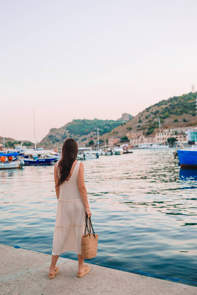 Young beautiful woman walking on dock near the boat  - Photo, Image