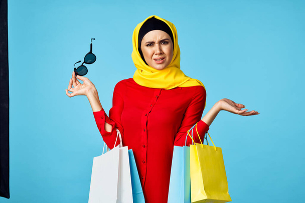 muslim woman in hijab shopping entertainment blue background - Foto, afbeelding