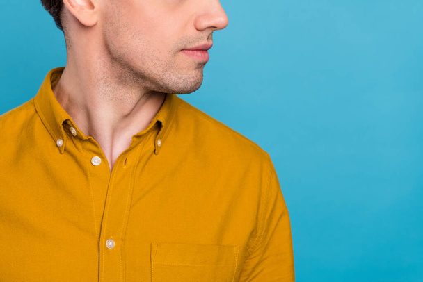 Cropped photo of masculine guy look empty space show silky skin wear yellow shirt isolated blue color background - Zdjęcie, obraz