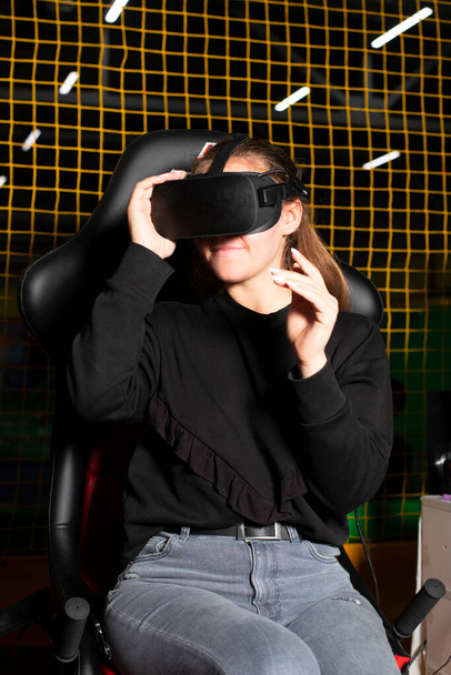 La vie virtuelle. Une fille en réalité virtuelle lunettes s'assoit dans une chaise de jeu - Photo, image