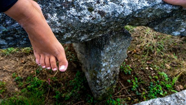 pied d'une jeune fille appuyé sur une table en pierre - Photo, image