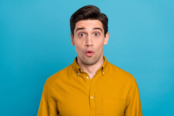 Photo of shocked impressed young man wear yellow shirt big eyes isolated blue color background - Fotografie, Obrázek