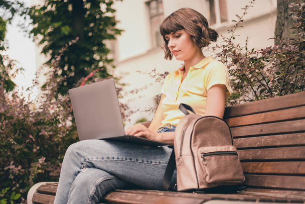Photo of serious charming focused young woman hold hands computer sit bench outside outdoors city town - Photo, image
