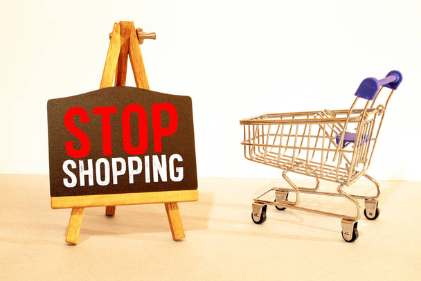the concept of refusing to buy a reasonable consumption is an inverted shopping basket with a padlock x keys and a sign with the inscription stop shopping. High quality photo - Foto, Bild