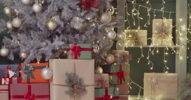 Interieur van woonkamer met veel geschenken onder kerstboom - Video