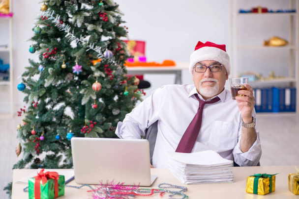 Empleado varón envejecido celebrando Navidad en el lugar de trabajo - Foto, imagen