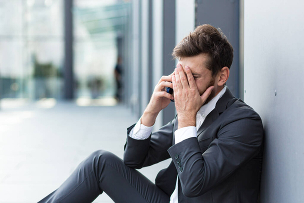 Déprimé homme en faillite pleurant près du bureau à l'extérieur, a perdu son emploi et l'espoir - Photo, image