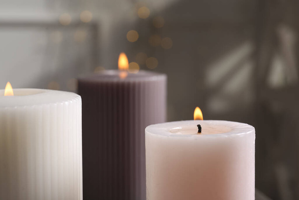 Different burning candles on blurred background, closeup - Foto, Bild