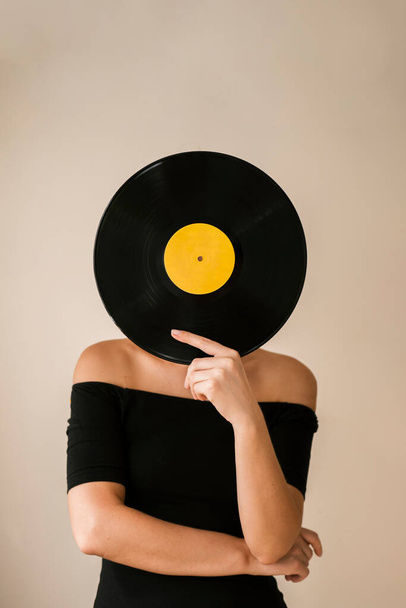 jeune femme tenant un disque vinyle son visage. Photo de haute qualité - Photo, image