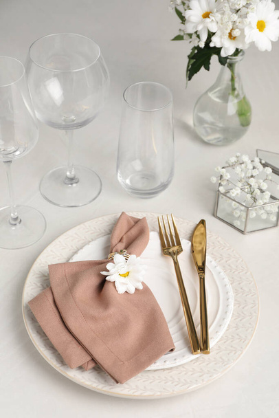 Beyaz masa üzerinde çiçek dekoru olan şık bir şenlik ortamı. - Fotoğraf, Görsel