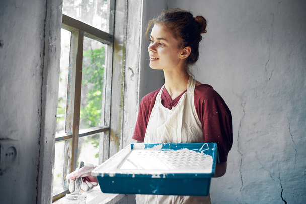 žena v zástěře malíř oprava malba okno - Fotografie, Obrázek