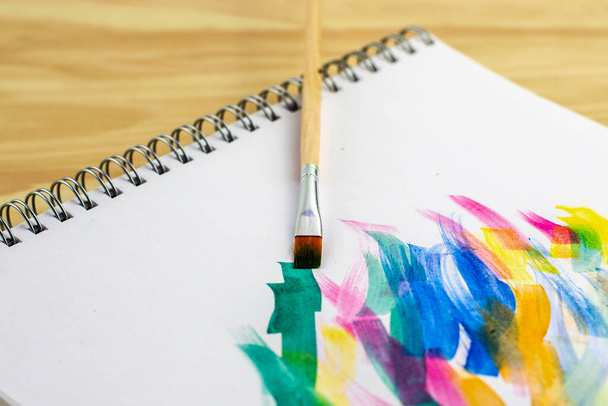 umělecký štětec na bílém listu papíru se vzorky akvarelových barev. Kvalitní fotografie - Fotografie, Obrázek
