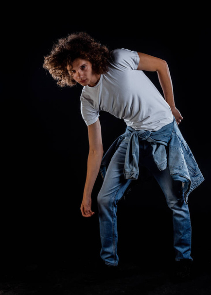 Portrait of an attractive young punk guy posing isolated on black background - Fotó, kép