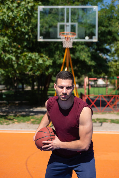 Portrét mladého basketbalisty na pouličním hřišti. - Fotografie, Obrázek