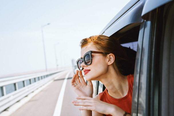 woman looking out of car window wearing sunglasses travel lifestyle - Фото, зображення