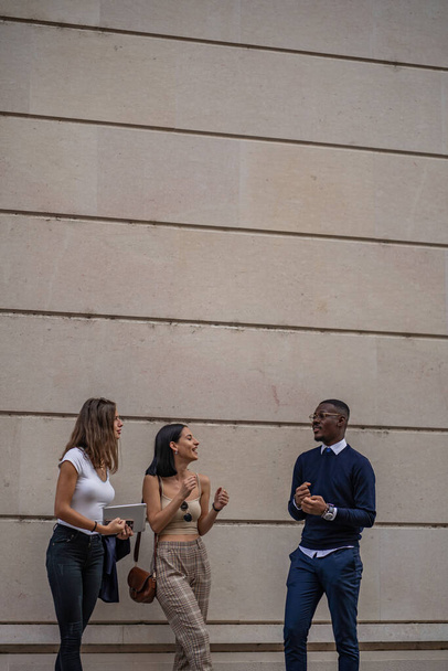 Drei multiethnische Geschäftspartner lachen und reden vor dem Unternehmen - Foto, Bild
