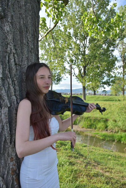 une fille en robe blanche avec un violon noir, - Photo, image